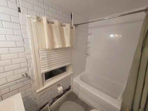 Room in Apartment - Blue Room in Delaware في دوفر: حمام أبيض مع دش وحوض استحمام