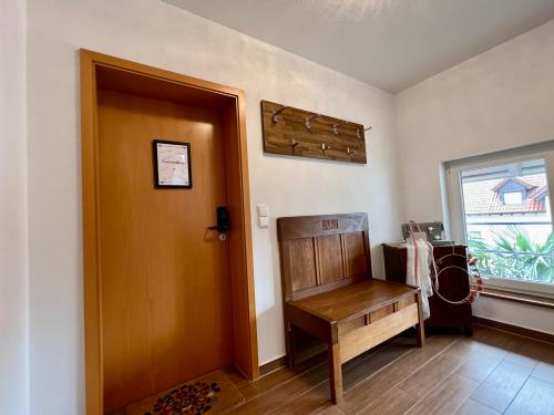 Cette chambre dispose d'une porte et d'un banc en bois. dans l'établissement Gemütliches Studio Apartment in Kehl Goldscheuer - 1A Guesthouse, à Kehl