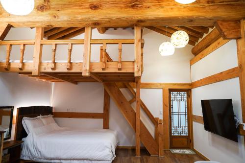 een kamer met een loft met een bed en een televisie bij Samlockhon Hanokstay in Jeonju