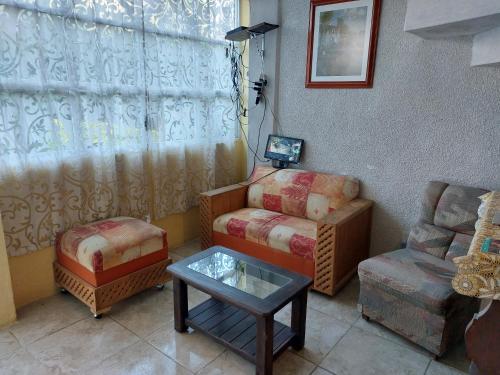 a living room with a couch and a chair and a table at Hospedajes Tomas Wilson MX in Mexico City