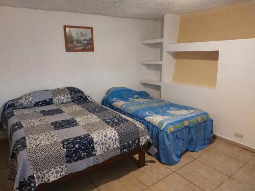 um quarto com duas camas e uma prateleira em Hospedajes Tomas Wilson MX em Cidade do México