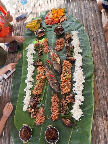 a table with a bunch of food on a banana leaf at The Beach House Ocam Ocam in Busuanga