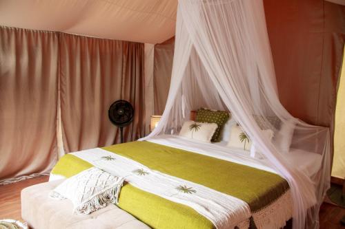 a bedroom with a bed with a canopy at Glamping tent in Pelaga Eco Park in Patjung
