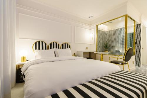 a bedroom with a large white bed and a desk at Yangju Hotel Ippda in Yangju