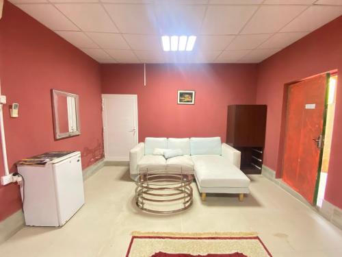 uma sala de estar com um sofá e uma mesa em Farmhouse One Bedroom Attached Bathroom em Al Rahba