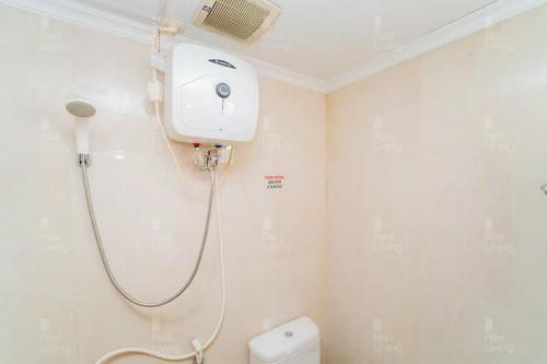 - biały prysznic w łazience z toaletą w obiekcie RedLiving Apartemen Green Lake View Cimanggis - WIN Property w mieście Depok