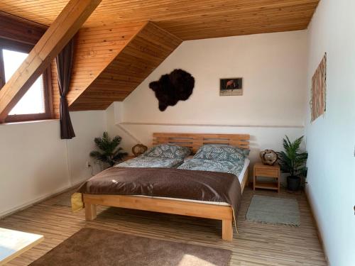 sypialnia z łóżkiem i drewnianym sufitem w obiekcie Penzión Pegas w Bratysławie