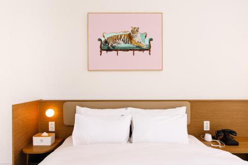 a bedroom with a bed with a cat on a couch at Yangju Hotel Ippda in Yangju
