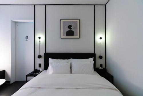 a bedroom with a large white bed with two lamps at Yangju Hotel Ippda in Yangju
