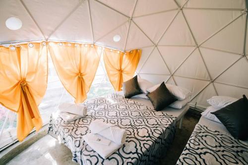 een kamer met 2 bedden in een tent bij Tranquil Retreat Dome Glamping with Hotspring Dipping pool - Breathtaking View in Lubo