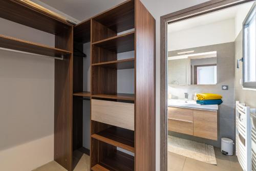 a bathroom with wooden shelves and a sink at Afa proche Ajaccio, magnifique villa avec piscine privée 8 personnes in Afa