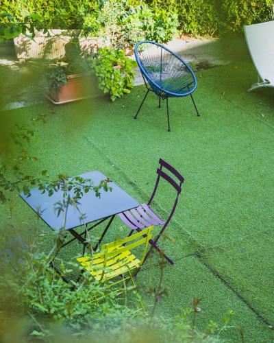 two chairs and a table in a yard with a table and a spiderweb at The Originals Boutique, Hôtel du Pont Roupt, Mende in Mende