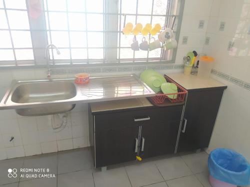 a kitchen with a sink and a counter top at PD Laguna Homestay Blue & Purple in Port Dickson