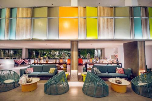 a lobby with couches and tables and a bar at IKOSHAROLD Resort Benoa in Nusa Dua