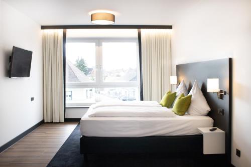 a bedroom with a large bed with a large window at ING Hotel by WMM Hotels in Ingolstadt