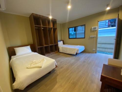 a hotel room with two beds and a window at U're Holitel in Haad Rin