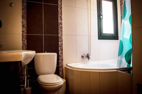 een badkamer met een toilet, een bad en een wastafel bij Nine Muses Villas - Clio Terpischori in Chersonissos