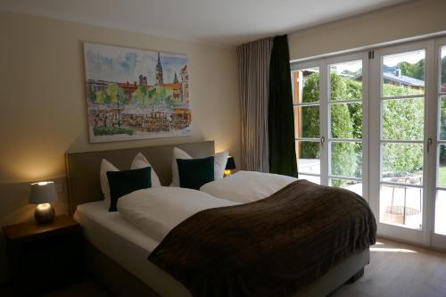 ein Schlafzimmer mit einem großen Bett und einem Fenster in der Unterkunft Bodenschneid Suiten Rottach-Egern in Rottach-Egern