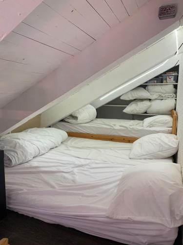 - un lit superposé avec des draps blancs et des oreillers dans l'établissement Les 2 Alpes studio centre station, à Les Deux Alpes