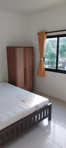 a bedroom with a bed and a large window at Ava 2 Budget Hotel Koh Tao in Ko Tao