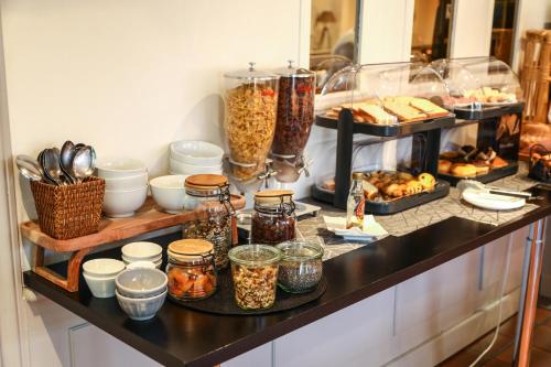 a counter with many jars of food and other foods at The Originals City, Hôtel Colmar Gare in Colmar