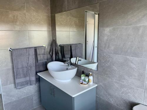 a bathroom with a sink and a mirror at Kindred Spirit Guest Suites with solar power in Knysna