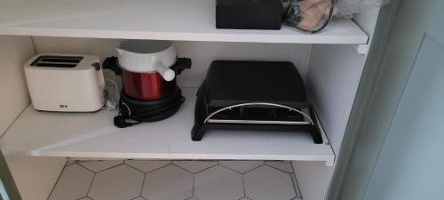 a kitchen shelf with a coffee maker and a blender at Les Colibris - Standing et Jardin - 3 étoiles in Cluses
