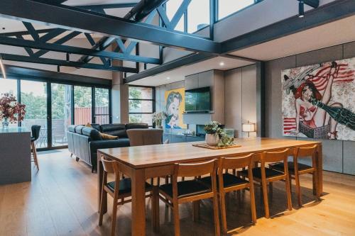 a dining room with a table and a living room at Mews Cottages in Gisborne