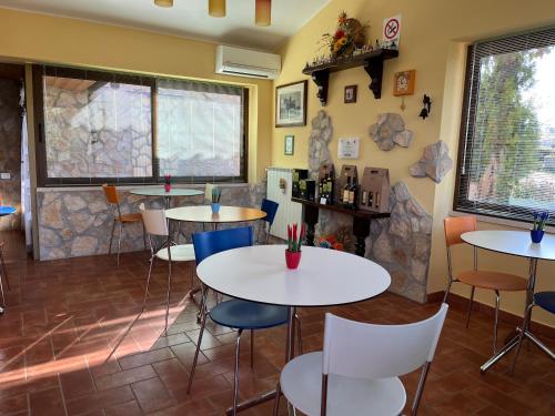 ein Restaurant mit Tischen und Stühlen und einem Kamin in der Unterkunft Agriturismo Poggio del Drago in Montemerano