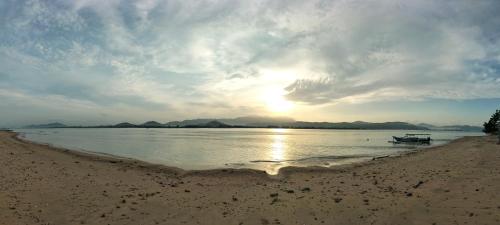 a boat sitting on the shore of a beach at Beach Camp Lombok in Sekotong
