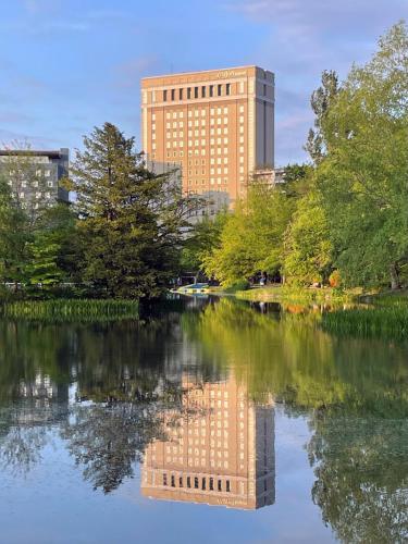 a reflection of a building in the water in a city at Hotel Lifort Sapporo in Sapporo