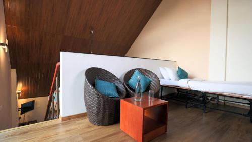 a room with a bed and a couch with blue pillows at Shola Crown Resort - Munnar in Chinnakanal