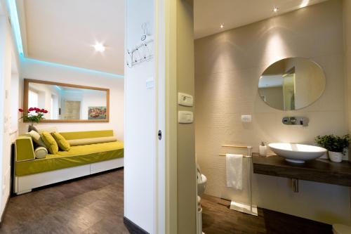 La salle de bains est pourvue d'un banc jaune et d'un lavabo. dans l'établissement Trullo Melograno - Dimore nel Tempo, à Alberobello
