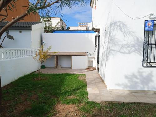 a white wall with a bench next to a yard at Villas Oropesa del Mar 3000 in Oropesa del Mar