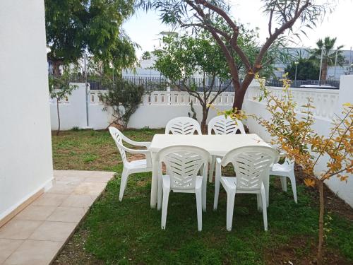 a white table and chairs in a yard at Villas Oropesa del Mar 3000 in Oropesa del Mar