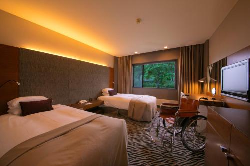 a hotel room with two beds and a flat screen tv at Niseko Northern Resort, An'nupuri in Niseko