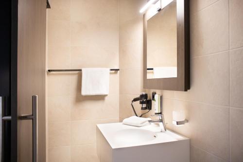 een badkamer met een wastafel en een spiegel bij MO Hotel by WMM Hotels in Ingolstadt