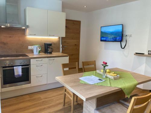 eine Küche mit einem Holztisch und einem Esszimmer in der Unterkunft Apartment Sonnwend in Reith im Alpbachtal
