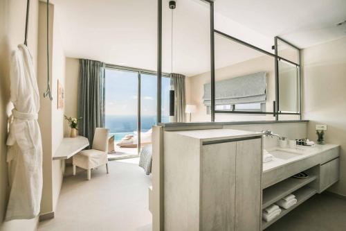 Un baño con lavabo y un espejo grande. en Villa Sorian Prasino, en Vlachata