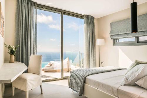 Un dormitorio con una cama y un escritorio y una ventana. en Villa Sorian Prasino, en Vlachata