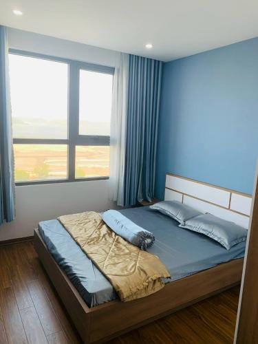 1 dormitorio con 1 cama con paredes y ventanas azules en Căn hộ du lịch Quy Nhơn giá rẻ-view biển 7, en Quy Nhon