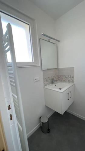 une salle de bain blanche avec un lavabo et une fenêtre dans l'établissement Maison 4 personnes dans village Cœur du perche avec toutes commodités Min 2 nuits, à Condé-sur-Huisne