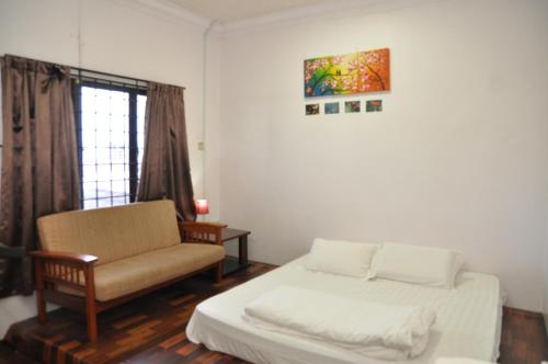 een kamer met een bed, een stoel en een raam bij 3 Little Birds Home, 100meter to JonkerWalk in Melaka