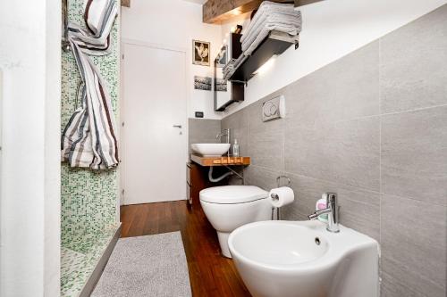 La salle de bains est pourvue de toilettes blanches et d'un lavabo. dans l'établissement STAGABIN La Mansarda Panoramica Un Rifugio di Eleganza e Tranquillità, à Turin