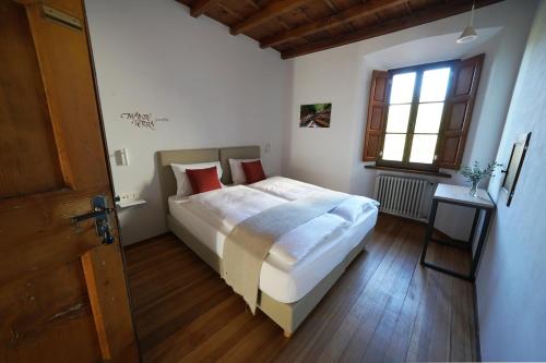 sypialnia z dużym łóżkiem i oknem w obiekcie Ar Convént B&B w mieście Bigorio