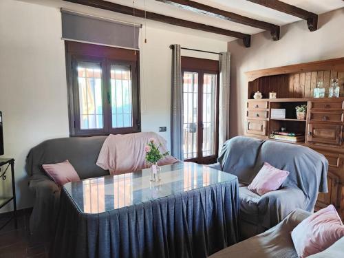 sala de estar con 2 sofás y mesa de cristal en Relax, vistas, barbacoa y piscina, junto a Ronda en Arriate