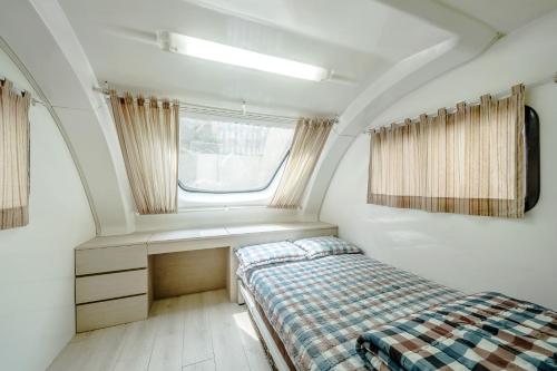 Habitación pequeña con cama y ventana en Club Lespia Pocheon 2nd Branch, en Pocheon