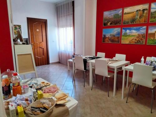 切利諾聖馬爾科的住宿－Colori Del Salento，一间设有白色桌椅和红色墙壁的用餐室