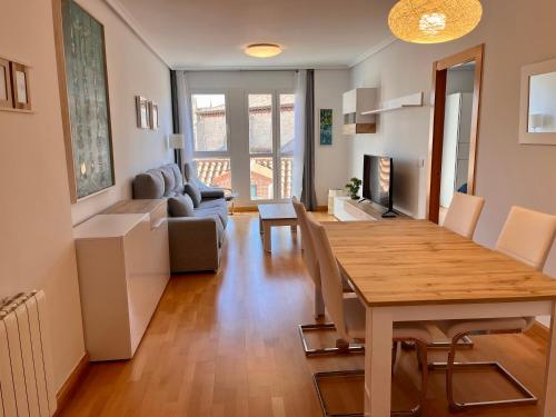 a dining room and living room with a table and chairs at Atuaire Home La Catedral en el salón PARKING INCLUIDO in Burgos