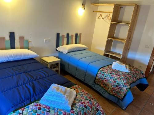 a room with two beds and a book shelf at Casas rurales La Trufa Madre Casa 3 in Vega del Cadorno